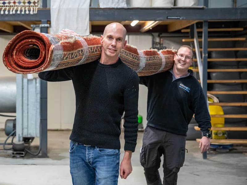 Close-up van medewerker die gabbeh vloerkleed scrubbt