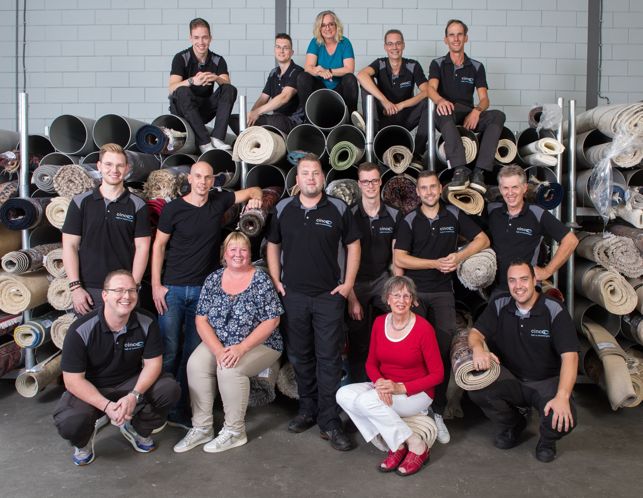 Het team in de bedrijfshal met opgerolde vloerkleden