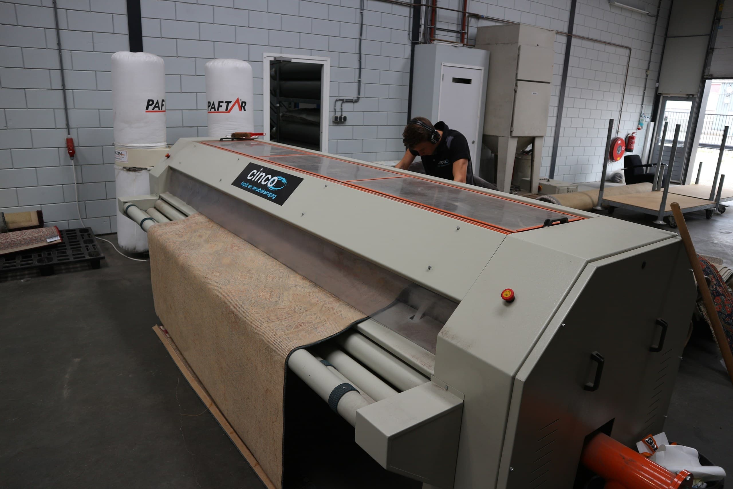Vloerkleed in de stofuitklopmachine in de wasserij