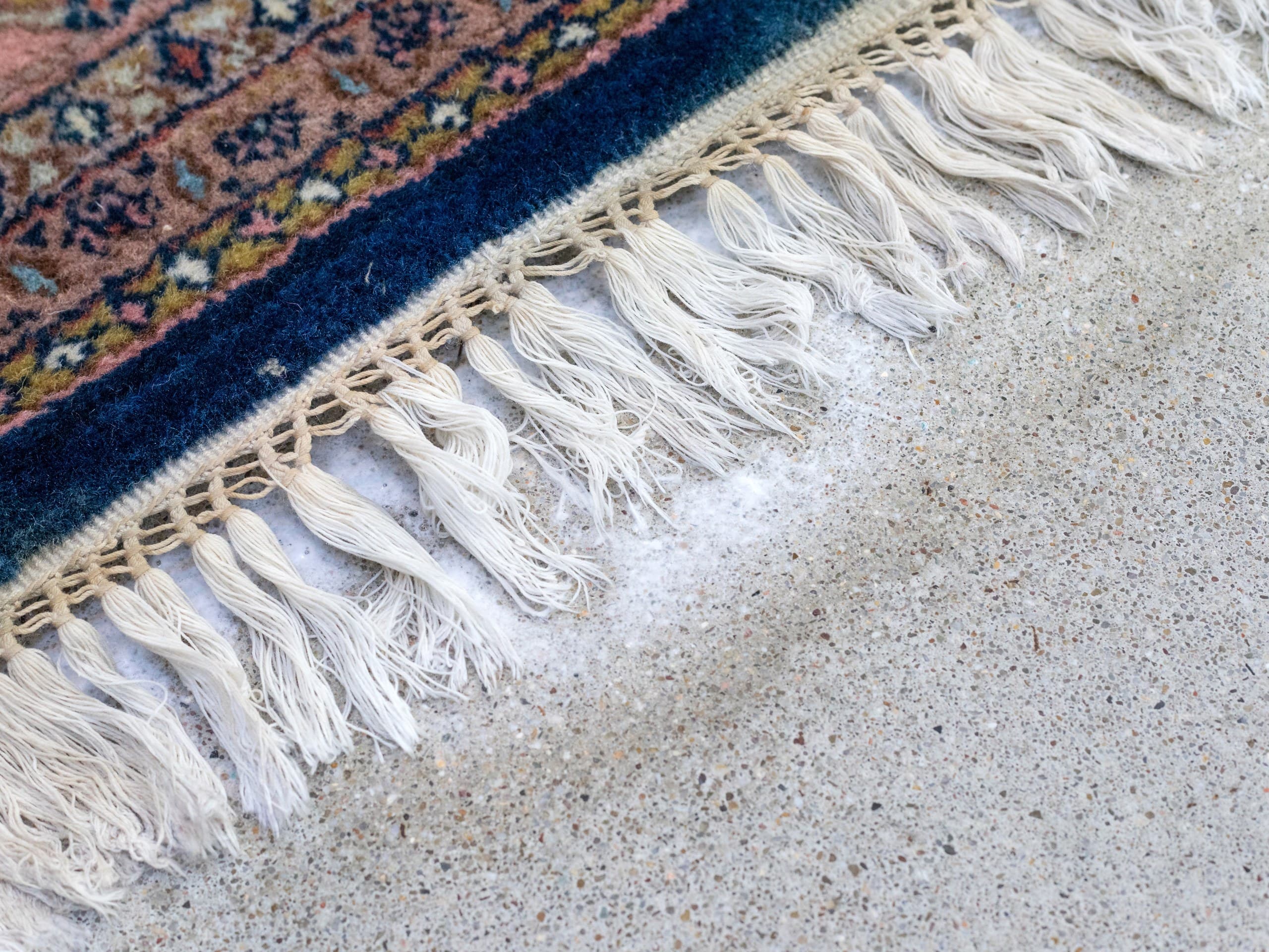 Detail van witte franje en patroon van een Perzisch vloerkleed